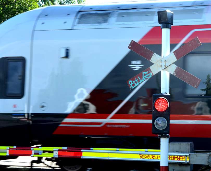 Tog passerer planovergang på Nordby stasjon.