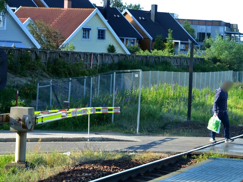 Person passerer planovergang på Nordby stasjon ulovlig.