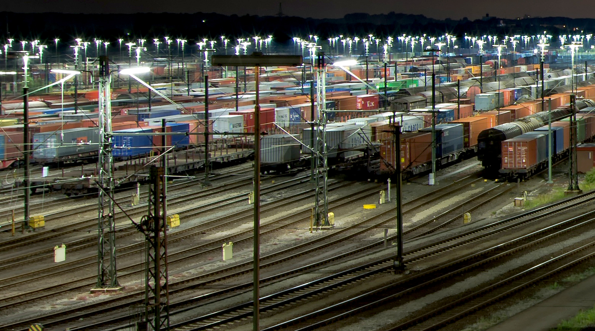 Togspor og godsvogner på togstasjon.