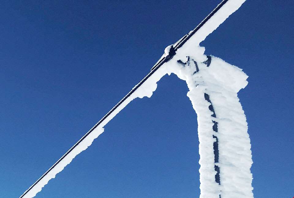 Ståltau i taubane dekt av snø.